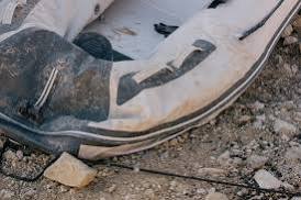 Close-up of a peeling seam on an inflatable boat tube, the failure mode behind persistent overnight air loss