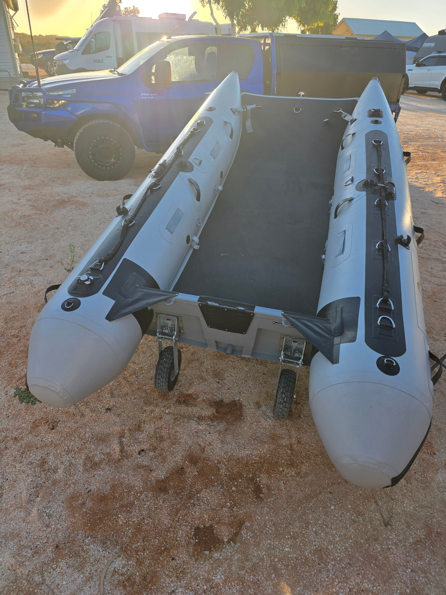 Aerowave inflatable catamaran on the beach with LockPro wheel kit, being rinsed down after a trip