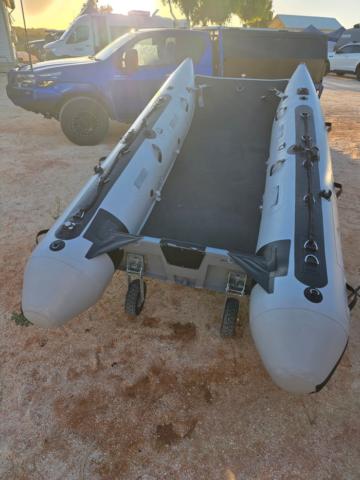 Aerowave inflatable catamaran on the beach with LockPro wheel kit, being rinsed down after a trip