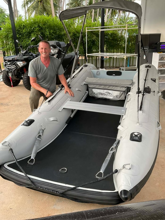 Easy Inflatables AeroCat 360 catamaran with an outboard motor beached on a pristine Australian estuary with eucalypts in the background.