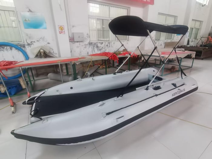 Aerowave WaveRunner 380 inflatable boat with grey and black bimini, side view on the water
