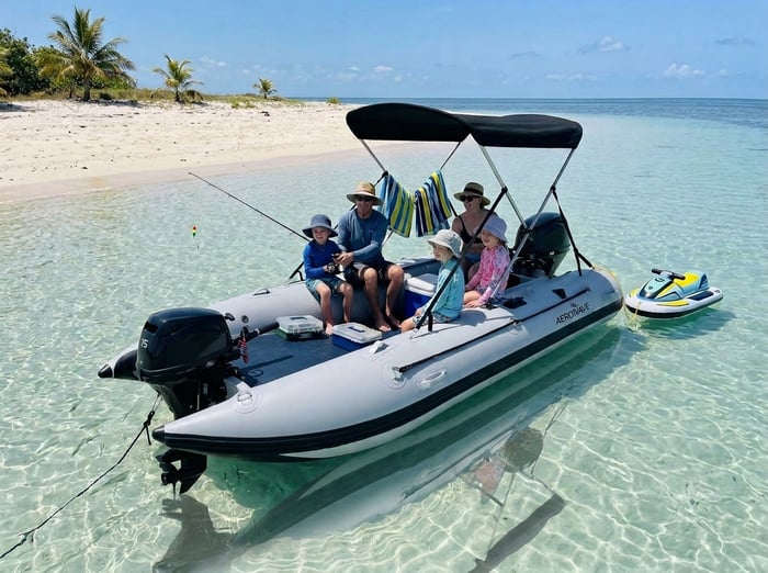 An Aerowave Viper inflatable catamaran cruising calmly on a turquoise Australian estuary at golden hour.