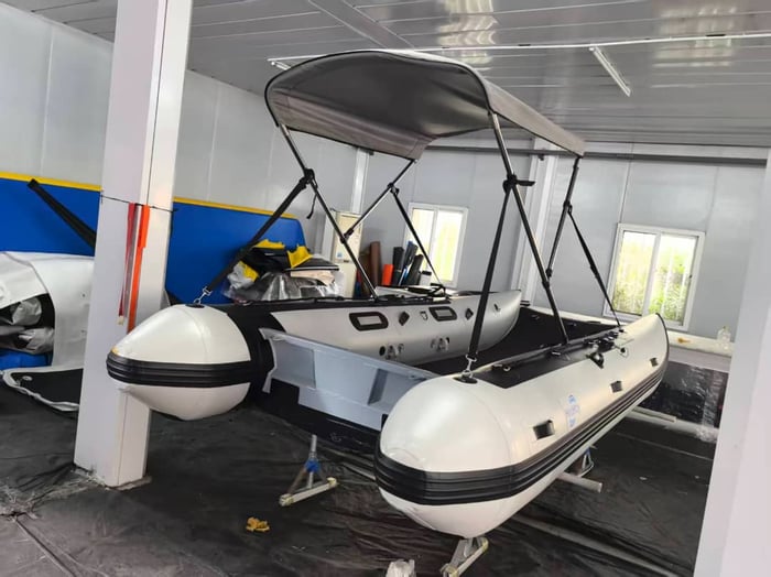 A real Aerowave Viper 365 inflatable catamaran with its Bimini fitted, ready beside the water for launching.