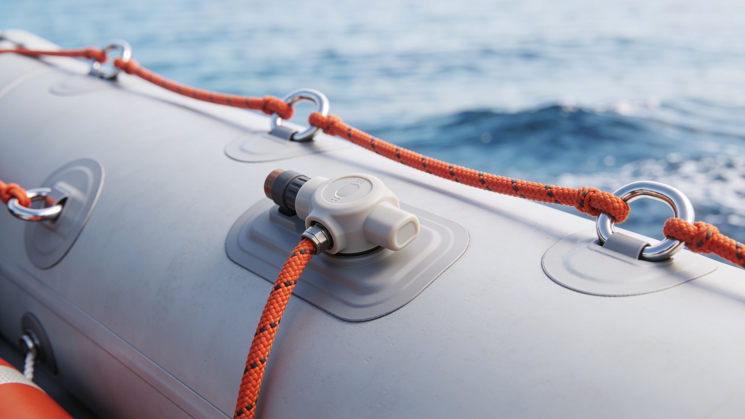 A close-up view of an inflatable rescue boat featuring safety ropes and an inflation valve.